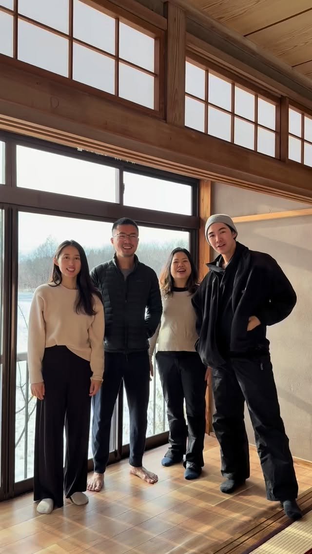 The four owners of Hibiki Lodge standing in the upstairs room, snow through the window behind them.